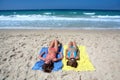 Two young girls laying on a sunny beach on vacation or holi Royalty Free Stock Photo