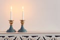 Two shabbat candlesticks with burning candles over wooden table