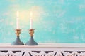 Two shabbat candlesticks with burning candles over wooden table