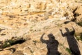 Two backpackers tourists friends shadows on desert ground. Royalty Free Stock Photo