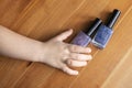 two shiny nail polishes, blue and purple, lie on a wooden surface Royalty Free Stock Photo