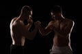 Two fighters facing each other on black background Royalty Free Stock Photo