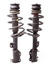 Two shock absorber struts with black springs after being used on a car during replacement and repair on a white isolated