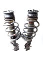 Two shock absorber struts with black springs after being used on a car during replacement and repair on a white isolated