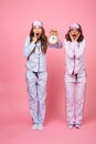 Two shocked confused screaming friends women holding alarm