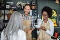 Two shop workers showing goods to female client