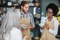 Two shop workers showing goods to female client