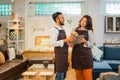 two shopkeepers with excited expressions while looking at a tablet