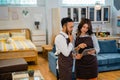 two shopkeepers with serious expressions while looking at a tablet Royalty Free Stock Photo