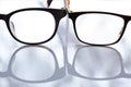 Two shortsighted or nearsighted eyeglasses on white acrylic table background, Close up & Macro shot, Reflection, Optical concept