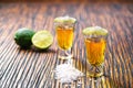 Two shot of gold tequila on a brown wooden background ,selectiv Royalty Free Stock Photo