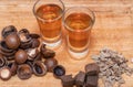 Two shot of home-brewed whiskey stand on a wooden board