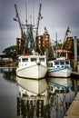 Two shrimp boats docked with a reflection in the calm water. Royalty Free Stock Photo