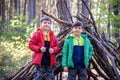 Two sibling brothers boys In the spring or autumn pine forest pl