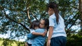 Two sibling little girls with mom laughing and hugging each other on warm and sunny summer day in the garden. Young girls with her Royalty Free Stock Photo