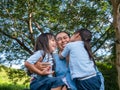 Two sibling little girls with mom laughing and hugging each other on warm and sunny summer day in the garden. Young girls with her Royalty Free Stock Photo