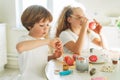 Two siblings brother and sister toddler boy tween girl painting easter eggs on kitchen at the home on spring sunny day Royalty Free Stock Photo