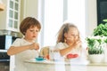 Two siblings brother and sister toddler boy tween girl painting easter eggs on kitchen at home on the spring sunny day Royalty Free Stock Photo