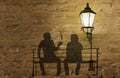 Two silhouettes on a bench