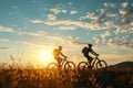 Two silhouettes enjoying outdoor activity, riding bicycles against beautiful morning sunrise