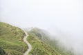 Two silhouettes walking on mountain path in fog