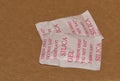 Two Silica gel packets isolated in a cardboard box.