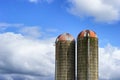 Two Silos against a partically cloudy sky