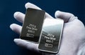 Two silver bars in the hand, dressed in a white protective glove. Royalty Free Stock Photo