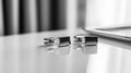 Two silver cufflinks sit on a table Royalty Free Stock Photo