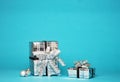 Two silver shiny boxes with a bow - New Year`s gift under a Christmas tree with blue background Royalty Free Stock Photo