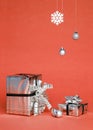 Two silver shiny boxes with a bow - New Year`s gift under a Christmas tree with red background Royalty Free Stock Photo