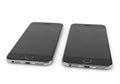 Two silver smartphones side by side isolated on white background Royalty Free Stock Photo