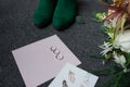 Two silver wedding rings and an engagement ring on the envelope. Green bridal shoes, a part of wedding bouquet and a wedding compl Royalty Free Stock Photo
