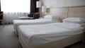 Two single beds in a cozy hotel room. Two elegant single beds in a spacious hotel room. A room with beds in a hotel