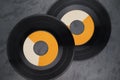 Two single vinyl records with wide-hole on black background