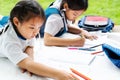 Two sister girl writes to writing-books. The decision of lessons. girl lay down drawing the picture Royalty Free Stock Photo