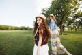 Two sisters in boho outfits are walking around the village. Beautiful, summer landscape. Country Holiday...