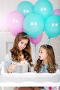 Two sisters with cake and balloons, birthday concept