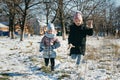 Two sisters of different ages on a winter walk in a snowy park Royalty Free Stock Photo