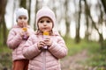 Two sisters drink juice using straws at forest, happy child moments Royalty Free Stock Photo