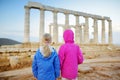 Two sisters exploring the Ancient Greek temple of Poseidon at Cape Sounion, one of the major monuments of the Golden Age of Athens Royalty Free Stock Photo