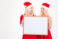 Two sisters holding blank board and looking on each other Royalty Free Stock Photo