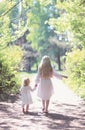 Two sisters holding hands walking in the forest Royalty Free Stock Photo