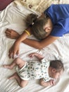 Two sisters a infant baby and teen age girl sleeping on bed together, top view Royalty Free Stock Photo