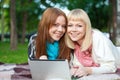 Two sisters with laptop in the park Royalty Free Stock Photo