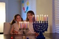 Sisters looking at candelabrum on the eight day of Hanukkah Jewish holiday festival