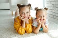 Two sisters are lying on the carpet at home. Royalty Free Stock Photo