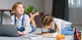 Two sisters lying on the floor at living room using laptop, playing and drawing Royalty Free Stock Photo