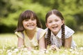 Two sisters lying outdoors smiling Royalty Free Stock Photo