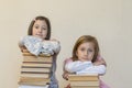 Two sisters with a pile of books on the floor in the room. The concept of education and development of children. Love of Royalty Free Stock Photo